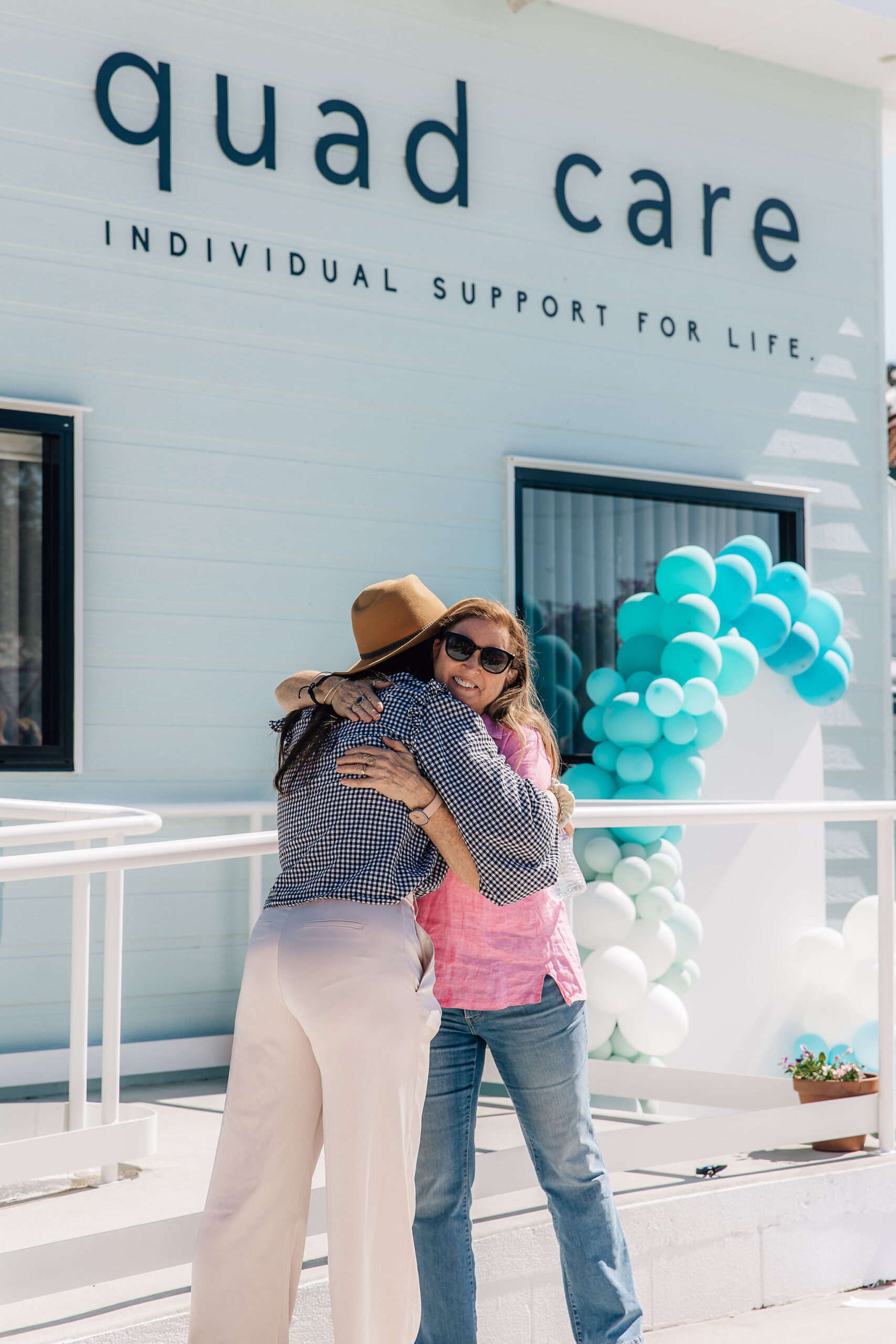 the owner Dani and her mother in law hugging at the front of the community hub on open day