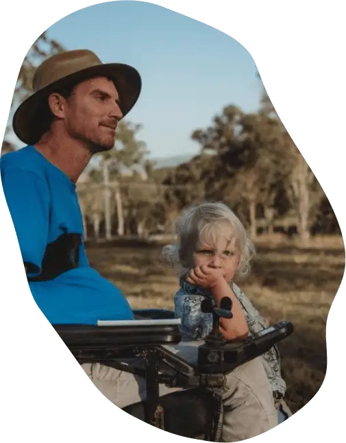 Man using a wheelchair spending time with his son outdoors.